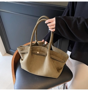Détail du cabas en daim vert olive avec boucle magnétique et texture douce au toucher