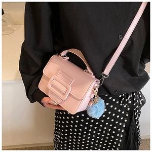 Vista dettagliata della borsa rosa con fibbia decorativa e accessorio pompon blu