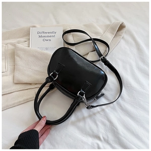 Top view of glossy black mini bowling bag with silver zipper and adjustable strap