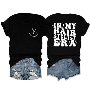 Flat lay of front and back hair stylist era t-shirt with distressed denim shorts