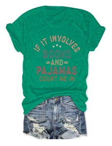 Flat lay of bright green round neck T-shirt with book graphic and distressed denim shorts