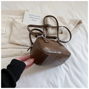 Close-up of brown glossy PU leather bowling bag with silver hardware and adjustable strap