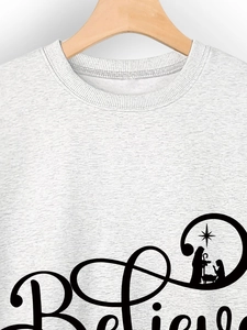 Detail of grey sweatshirt with Believe lettering and nativity scene silhouette design