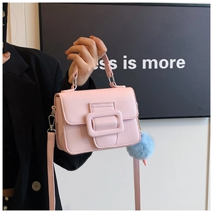 Dettaglio della piccola borsa quadrata rosa con fibbia in pelle e ciondolo blu chiaro