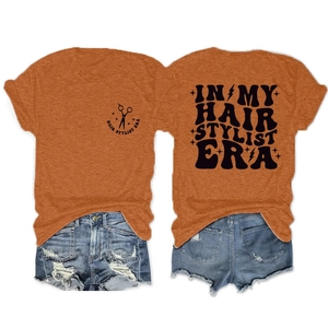 Front and back view of orange Hair Stylist Era T-shirt with blue ripped denim shorts