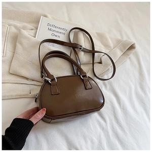 Detail of vintage brown leather bowling bag with silver hardware and adjustable strap
