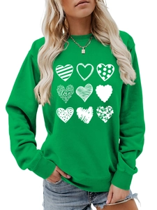 Detailed view of nine white heart prints with LOVE text on a green cotton sweatshirt