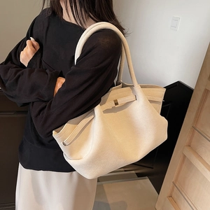 Grand sac cabas en daim beige minimaliste porté par un mannequin dans un intérieur