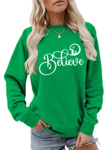 Detail of green crewneck sweatshirt with white Believe Christmas nativity scene graphic