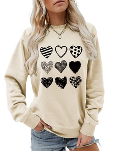 Macro detail of 3x3 heart matrix prints and love script on beige crewneck sweatshirt