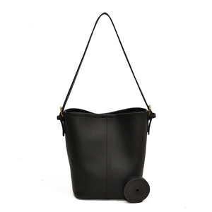 Sac seau chic en cuir noir avec texture grainée et anneaux métalliques dorés élégants