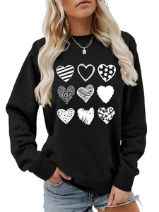 Close-up of black crew neck sweatshirt featuring nine artistic white heart patterns