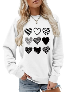 Detail of printed love hearts and cursive text on a white long-sleeved sweatshirt