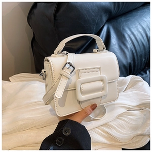 Dettaglio della piccola borsa bianca vintage con fibbia grande e manico in pelle in mano