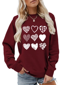 Detailed view of the white nine-heart print and love text on a burgundy sweatshirt
