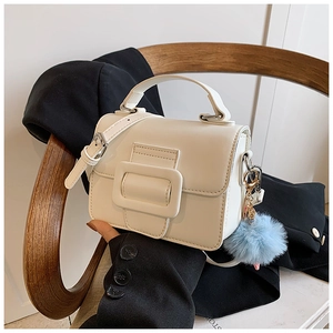 Vista dettagliata di una piccola borsa bianca strutturata con fibbia quadrata decorativa