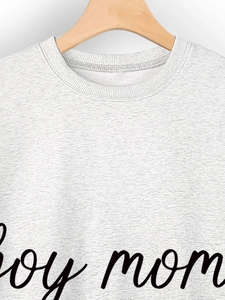 Close-up of boy mom print on light grey marl crewneck sweatshirt on wooden hanger