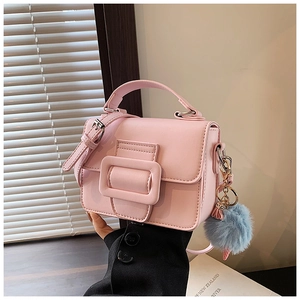 Dettaglio della borsa in pelle rosa con manico e ciondolo in ecopelliccia azzurro chiaro