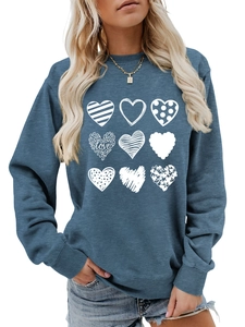 Detail of navy blue crewneck sweatshirt featuring nine artistic white heart prints and LOVE text