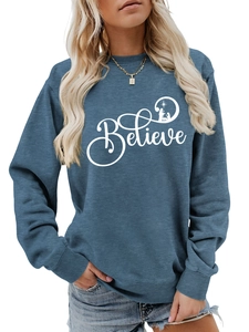 Detail of blue crewneck sweatshirt featuring white Believe lettering and nativity silhouette