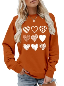 Detail of orange crewneck sweatshirt with nine white artistic heart patterns and love text