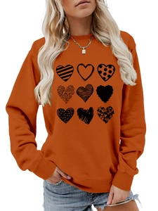 Detail of orange crewneck sweatshirt featuring nine unique black heart graphic prints