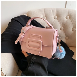 Dettaglio borsa a mano in pelle PU rosa con grande fibbia e pompon blu decorativo