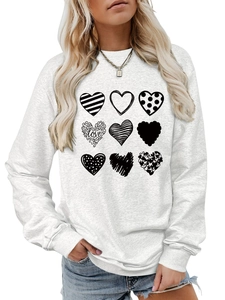 Close-up of nine artistic heart prints and love lettering on a grey crewneck sweatshirt