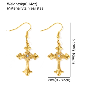 Detail of gold stainless steel cross earrings with white rhinestones and ornate engraving