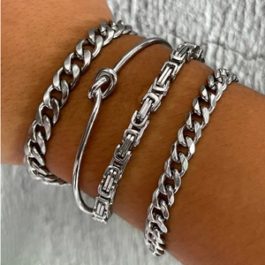 Close-up of four-piece silver stainless steel stacked Cuban link and Byzantine chain set