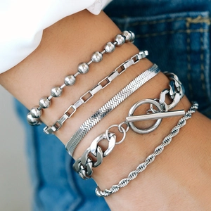 Close-up of five-piece silver chain bracelet set with OT buckle on a woman's wrist