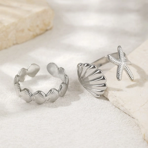Macro detail of silver stainless steel starfish and seashell adjustable open rings