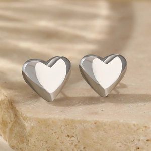Minimalist silver heart stud earrings with a polished finish on a natural stone base
