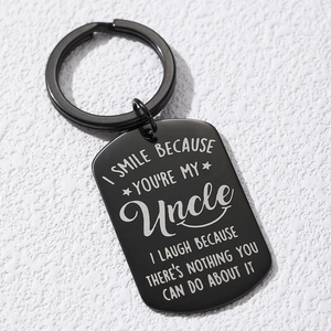 Close-up of matte black stainless steel dog tag keychain with engraved funny uncle message