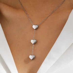 Detail of silver heart pendants on a Y-shaped stainless steel chain necklace