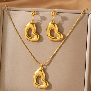 Parure boucles d'oreilles et collier cœur doré poli sur présentoir de luxe