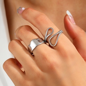 Detail of silver textured irregular wide ring and twisted rope band worn on model fingers