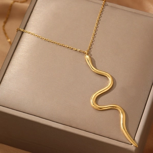 Collier élégant avec pendentif serpent doré et finition polie sur une boîte à bijoux