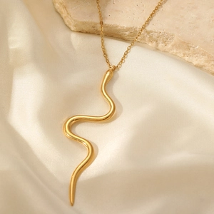 Collier minimaliste serpent doré sur tissu en soie blanche avec décor de pierre