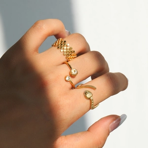 Detailed view of three gold titanium rings including honeycomb and snake textures