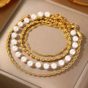 Bracciale multistrato dorato con perle finte e catene intrecciate da donna
