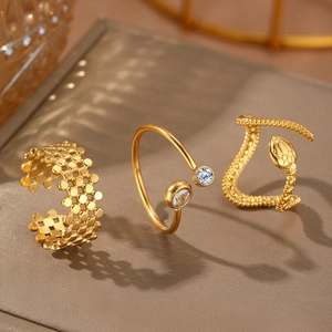 Detailed view of three gold-plated titanium rings featuring a snake shape and zircons