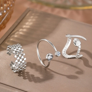 Three-piece silver hollow heart and snake pattern adjustable ring set on display