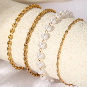 Dettaglio del set di bracciali a quattro strati in oro e perle finte su espositore