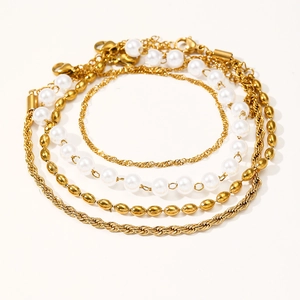Set di quattro bracciali dorati con perle vintage e catene geometriche a più strati