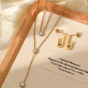 Detailed view of gold Y-shaped necklace and matching rectangle crystal stud earring set