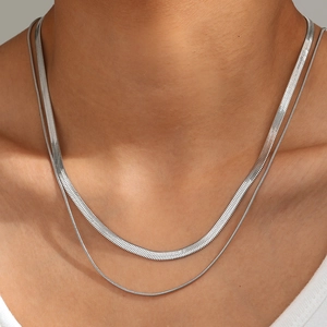 Detail of silver double-layered snake chain necklace with flat and round textures