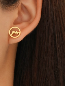 Close-up of a woman wearing gold mountain silhouette earrings made of stainless steel