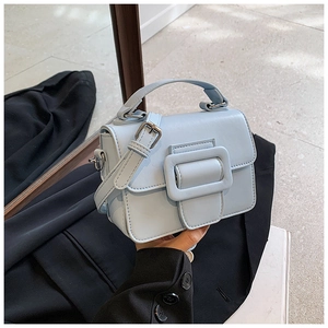 Dettaglio della piccola borsa azzurra con fibbia decorativa e tracolla sottile