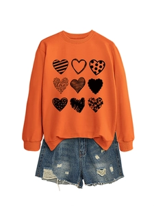 Close-up of bright orange crewneck sweatshirt featuring nine artistic heart graphics and LOVE text